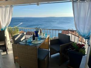 a table on a balcony with a view of the ocean at Tanis Ocean Loft in Martinšćica