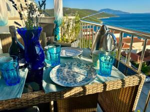 a table with plates and glasses on a balcony at Tanis Ocean Loft in Martinšćica