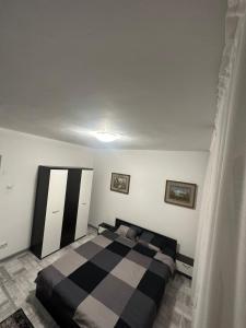a bedroom with a black and white bed in it at Apartament Calea Grivitei Podul Grand in Bucharest