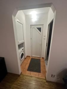 a hallway with a door leading to a room with a washing machine at Apartament Calea Grivitei Podul Grand in Bucharest