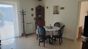comedor con mesa, sillas y ventana en Cà Zelinda House Holiday, en Moneglia