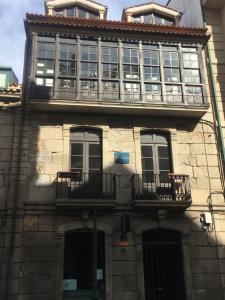 a building with windows and balconies on the side of it at Fogar de Breogán "LOFT NÓS" in Caldas de Reis