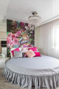 a bedroom with a large bed with a colorful wall at Apartament Termalny DELUX in Uniejow