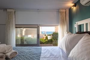 a bedroom with a bed and a large window at Oddas Beach House in Rethymno Town