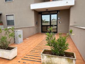 an empty patio with potted plants in front of a building at Calamaterdomini a 2 passi dal mare in Brindisi