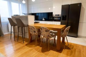 uma cozinha com uma mesa de madeira e cadeiras em Apartament Termalny DELUX em Uniejow