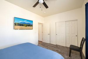 um quarto com uma cama azul e uma ventoinha de tecto em Mt. Elden Adventure em Flagstaff