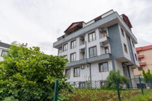 a white building with a fence in front of it at Flora Trabzon Apart in Pelitli