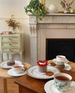 a table with two cups of coffee and muffins at Appartement de charme proche château et forêt in Fontainebleau