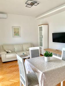 a living room with a table and a couch at Talija Apartments in Bijela
