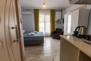 a kitchen and a living room with a bed in a room at Flora Trabzon Apart in Pelitli