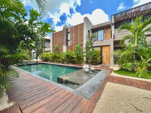 an exterior view of a villa with a swimming pool at TOH Tulum - 2 Bedroom Apartments - Fiber WiFi in Tulum