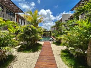 トゥルムにあるTOH Tulum - 2 Bedroom Apartments - Fiber WiFiのヤシの木が植えられた庭の中央のプール