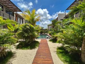 a pool in the middle of a yard with palm trees at TOH Tulum - 2 Bedroom Apartments - Fiber WiFi in Tulum