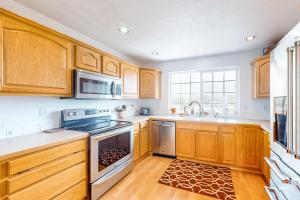 a kitchen with wooden cabinets and stainless steel appliances at JS Beach House in Lincoln City