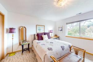 a bedroom with a bed and a mirror and a window at JS Beach House in Lincoln City