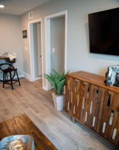 1 Bedroom Stylish Oasis في أوماها: غرفة معيشة مع تلفزيون بشاشة مسطحة على جدار
