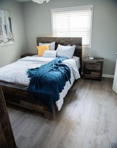 1 Bedroom Stylish Oasis في أوماها: غرفة نوم عليها سرير وبطانية زرقاء