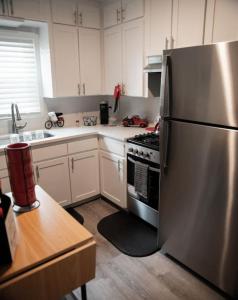 a kitchen with a stainless steel refrigerator and white cabinets at 1 Bedroom Stylish Oasis in Omaha