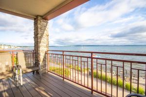 a balcony with a bench overlooking the beach at Tamarack Lodge in Traverse City