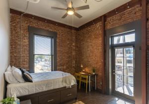 una camera da letto con pareti in mattoni, letto e ventilatore a soffitto di Tomorrow Building at Patten Parkway a Chattanooga