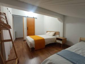 a small bedroom with two beds and a ladder at La casa de Cristina in El Dueso