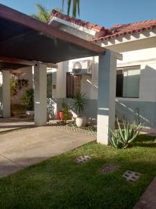 une maison avec une terrasse couverte et une allée. dans l'établissement PEQUEÑO y ACOGEDOR DEPARTAMENTO CON GARAJE y recibe PEQUEÑOS PELUDITOS, à Santa Cruz de la Sierra