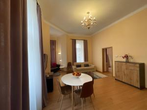 uma sala de estar com uma mesa branca e cadeiras em Anzio apartments em Mariánské Lázně
