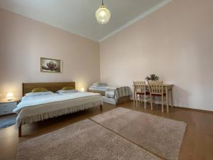 a bedroom with two beds and a table and chairs at Anzio apartments in Mariánské Lázně