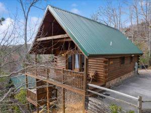 une cabane en rondins avec un toit vert dans l'établissement Breathtaking views of the Smokies, 3 mins to Gatlinburg, à Gatlinburg