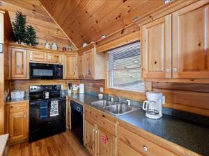 a kitchen with wooden cabinets and a black appliance at Breathtaking views of the Smokies, 3 mins to Gatlinburg in Gatlinburg