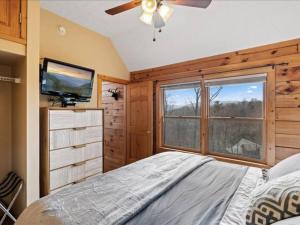 a bedroom with a bed and a tv and a window at Breathtaking views of the Smokies, 3 mins to Gatlinburg in Gatlinburg