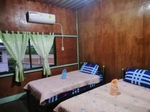 a room with two beds and a window at Lungmin homestay in Mae Hong Son