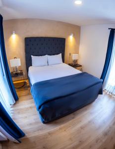 1 dormitorio con 1 cama grande con sábanas azules en Hotel Pietro Santo, en Santeagueda