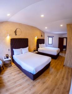 2 camas en una habitación de hotel con suelo de madera en Hotel Pietro Santo, en Santeagueda