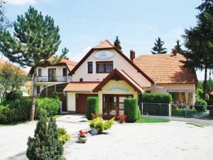 a house with a clock on the top of it at Erika Apartmanházak in Hévíz
