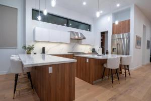 una cocina con encimeras blancas y armarios de madera en New High-End Luxury Pet-Friendly Villa, en Los Ángeles