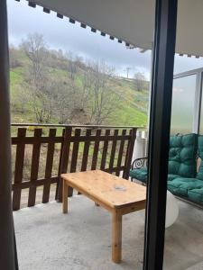 una mesa de madera en un balcón con vistas en Appartement Montagne, en Saint-François-Longchamp