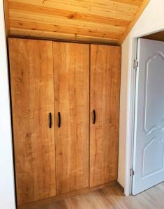 duża drewniana szafka w pokoju z sufitem w obiekcie Racha Twins w mieście Nikortsminda