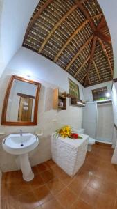 a bathroom with a sink and a mirror and two toilets at Hosteria Cumilinche in Same