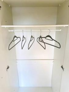 a group of four hangers in a room with a wall at Private Gated Studio Flat in Buckinghamshire