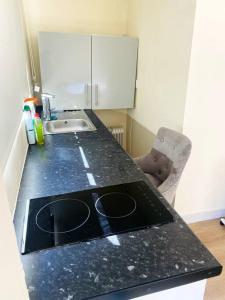 a kitchen with a black counter top and a sink at Private Gated Studio Flat in Buckinghamshire