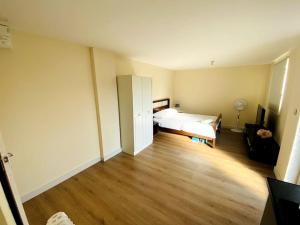 1 dormitorio con 1 cama y suelo de madera en Private Gated Studio Flat, en Buckinghamshire