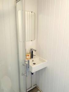 y baño con lavabo blanco y espejo. en Private Gated Studio Flat, en Buckinghamshire