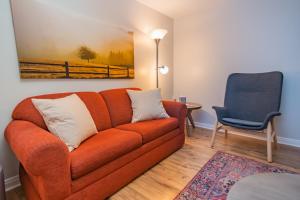 ein Wohnzimmer mit einem orangenen Sofa und einem blauen Stuhl in der Unterkunft South Zion Inn and Suites in Hildale