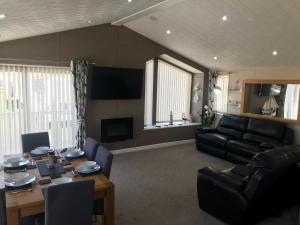 a living room with a table and a couch at Hot Tub Accommodation North Wales Lodge in Rhyl