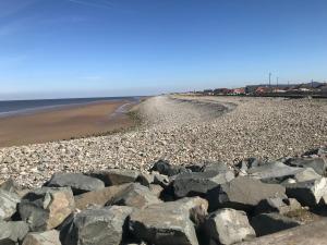 a beach with rocks on the shore at Hot Tub Accommodation North Wales Lodge in Rhyl