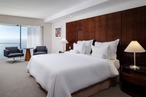 uma grande cama branca num quarto de hotel com uma janela em Rio Othon Palace no Rio de Janeiro