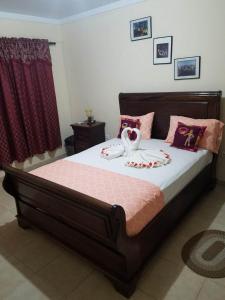 1 dormitorio con 1 cama grande con almohadas rosas en Casa Alegre, en São Filipe