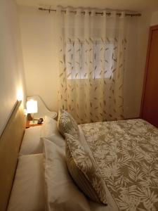 a bed with pillows on it in a bedroom at Brisas del Mar in Salou +11 photos